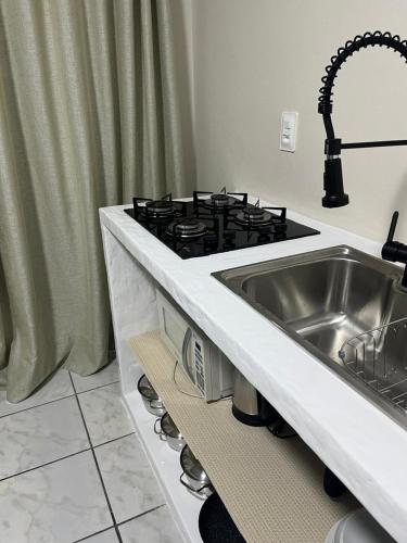a kitchen with a sink and a stove at Casa no Centrinho para 2 pessoas 100m do Mar in Bombinhas