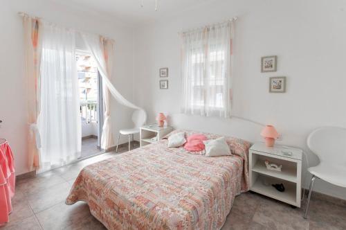 a bedroom with a bed and a table and windows at Oreneta in Puerto de Gandía