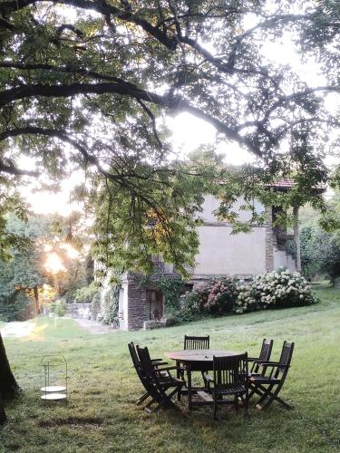 een picknicktafel en stoelen onder een boom bij La Bouriotte Chambre d'hôtes Bouton D'Or in Labastide-Rouairoux