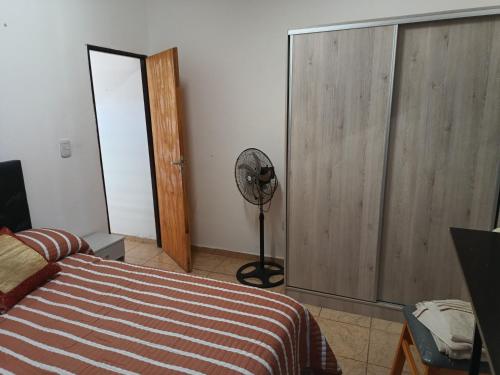 een slaapkamer met een bed en een ventilator bij Amageu in San Luis