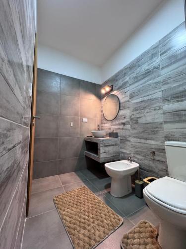 ein Badezimmer mit Toilette und Waschbecken in der Unterkunft Las Moradas Ale in Villa Carlos Paz