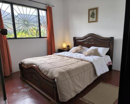 una camera da letto con un letto grande e una finestra di Hostal La Clarita a Fusagasugá