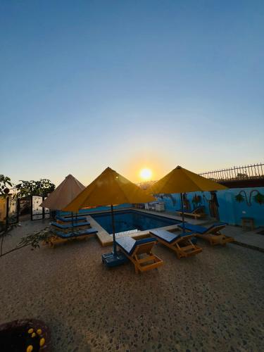 a group of chairs and umbrellas on a beach at Horus Golden Luxor in Luxor