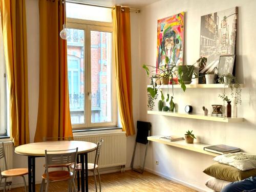 een eetkamer met een tafel en een raam bij Central Hub in Brussel