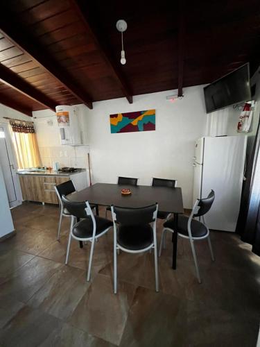 a kitchen with a table and chairs and a refrigerator at La Soñada in Miramar
