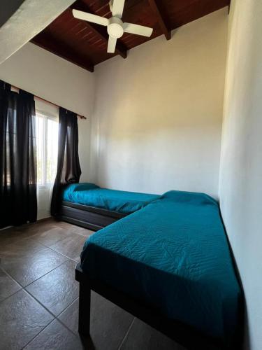 a bedroom with two beds and a ceiling fan at La Soñada in Miramar