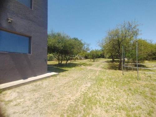 eine unbefestigte Straße neben einem Gebäude mit Bäumen in der Unterkunft Casa moderna con pileta in Bialet Massé