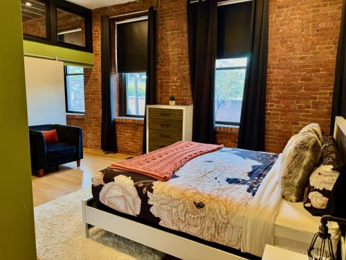 a bedroom with a bed and a brick wall at Brick City Loft in Newark