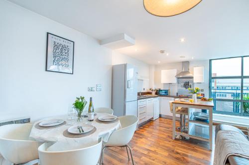 a kitchen and dining room with a table and chairs at Modern Leeds Apartment Close to LGI & University in Central Station