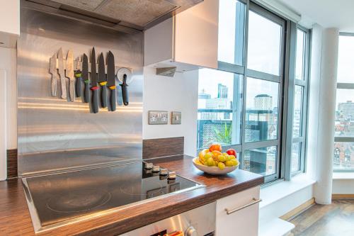 a kitchen with a counter with a bowl of fruit at Modern Leeds Apartment Close to LGI & University in Central Station