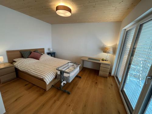een slaapkamer met een bed, een bureau en een raam bij Apartment Laura in Jenig