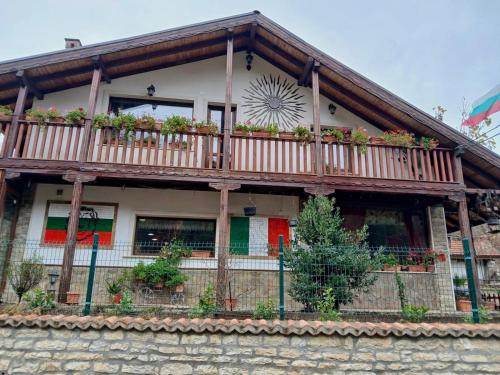a house with a balcony with flowers on it at Dolphin Residence Bulgaria in Zgorigrad