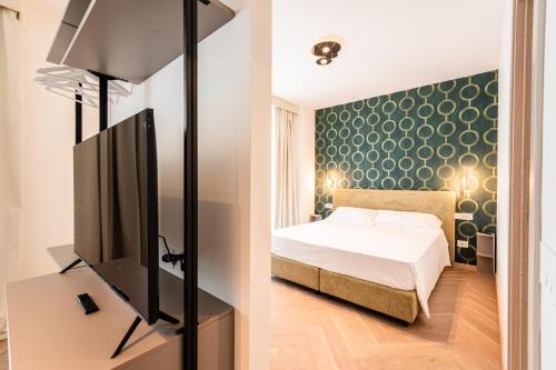 a bedroom with a bed and a flat screen tv at Palazzo Le Giare - Luxury Apartments in Bari