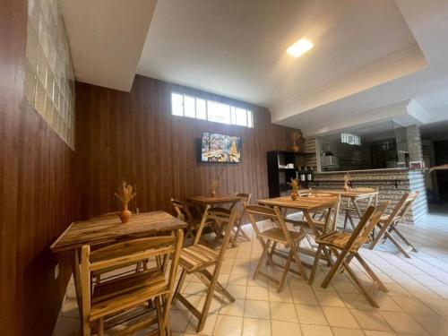een eetkamer met houten tafels en stoelen bij Pousada Terraço das Aguas Mcz in Maceió