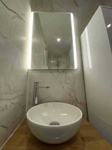 a white sink in a bathroom with a mirror at L'Escapade Cosy Proche Métro CHU et EHESP in Rennes