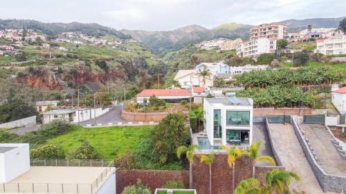 a view of a city with mountains in the background at Sunshine Villa with Optionally Heated Pool 150m above Ocean & Sandy Beach in Estreito da Calheta
