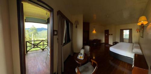 a hotel room with a bed and a balcony at Rose Cabin Kundasang in Ranau