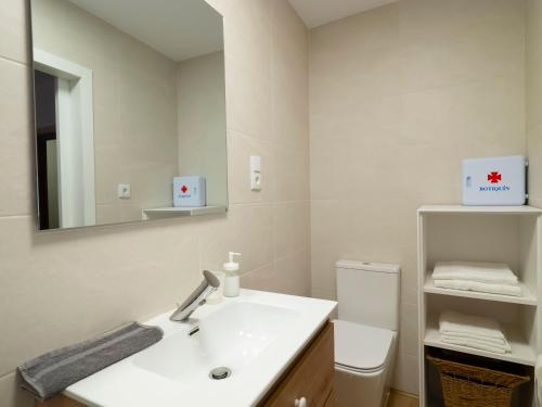 een badkamer met een wastafel en een spiegel en een toilet bij Casa de La Canita in Guadamur