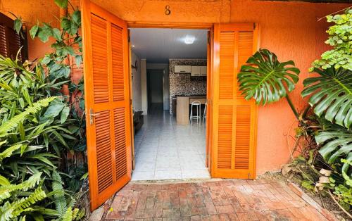 eine orangefarbene Tür, die in eine Küche in einem Haus führt in der Unterkunft Residencial Solar Três in Imbé