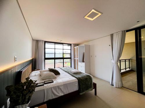 a bedroom with a bed and a large window at The house - Casa Coral in Trairi