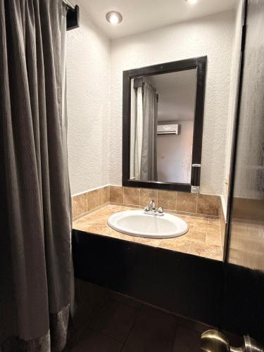a bathroom with a sink and a mirror at Hotel la Finca Inn in Matamoros
