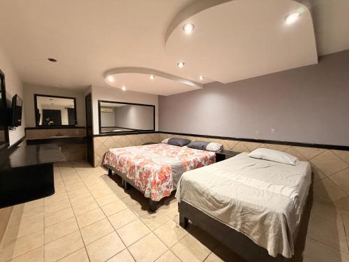 a hotel room with two beds and a mirror at Hotel la Finca Inn in Matamoros