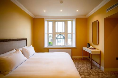 een slaapkamer met een groot bed en een raam bij The Hadley Hotel in New Barnet