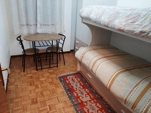 a bedroom with a bunk bed and a small table at Ca Irene in Conegliano