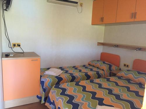 a bedroom with a bed with a colorful comforter at Camping Village Stella Mare in Lacona