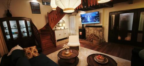 een woonkamer met een bank en een tv bij Wellness house Svjetlost in Jahorina
