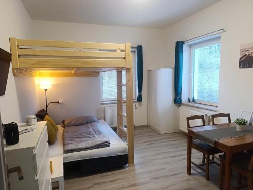 een kleine kamer met een stapelbed en een tafel bij Apartmán Denisa in Rokytnice nad Jizerou
