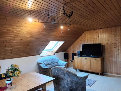 ein Wohnzimmer mit Tisch und Fernseher in der Unterkunft Ferienwohnung DFranz in Weitefeld