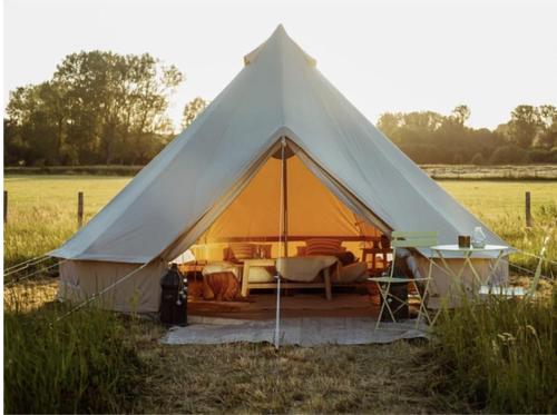een grote tent met een bed in een veld bij NaboCamp in Linares