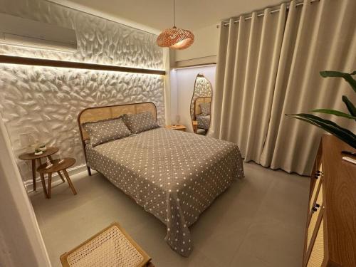 a small bedroom with a bed and a table at Praia do Rosa Park Studio in Guarapari