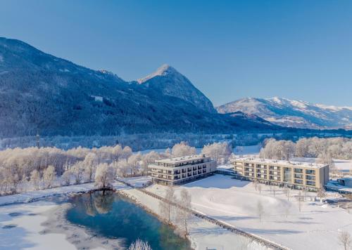 an aerial view of a building with snow and mountains at Dolomitengolf Suites in Lavant