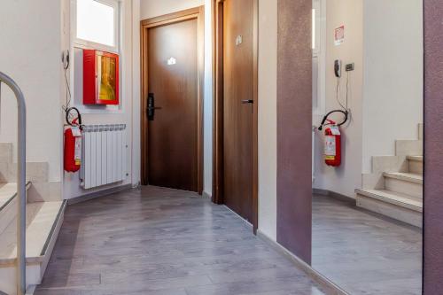 a hallway with a wooden door and a fire hydrant at Hotel POSTA - Comfortable Stay in Ventimiglia in Ventimiglia