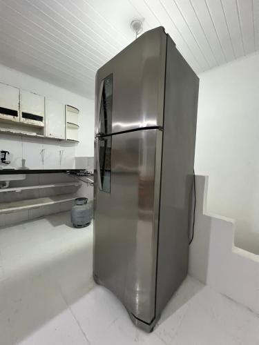 un réfrigérateur en acier inoxydable dans une cuisine blanche dans l'établissement casa branca, à Serra