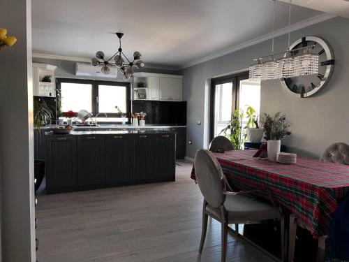 een keuken en eetkamer met een tafel met een rood tafelkleed bij Valmaris in Râmnicu Vâlcea