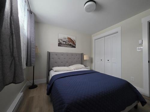 une chambre avec un lit avec une couverture bleue dans l'établissement Quiet Comfort Suite, à Moncton