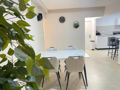 una sala da pranzo con tavolo e sedie bianchi di Ramon Palms a Mitzpe Ramon