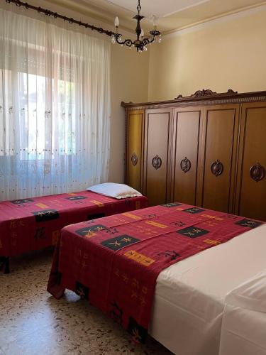 a bedroom with two beds and a chandelier at B&B Amurri Domenica in Grottammare