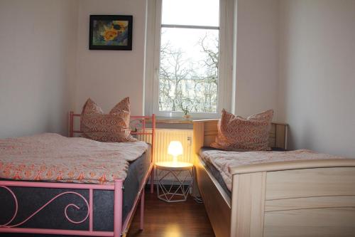 a small room with two beds and a window at Pension963 in Crimmitschau