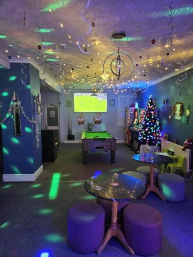 a room with ping pong tables and a christmas tree at Jesmond International Hotel in Blackpool