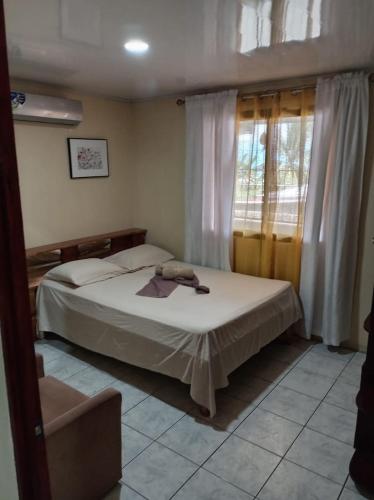 a bedroom with a bed and a window at HOSTEL CASA MARINA in Puerto Limón