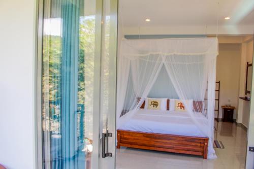 a bedroom with a bed with a canopy at The Birdy Retreat Ella in Ella