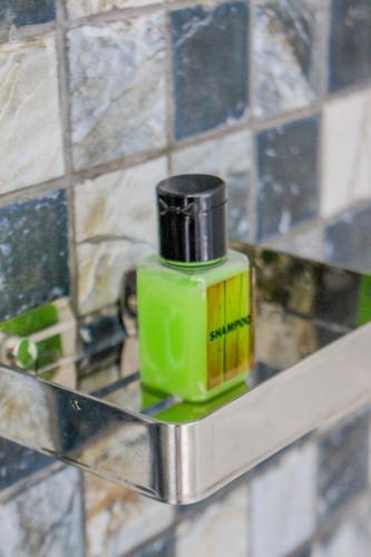 a green bottle sitting on a shelf in a bathroom at The Birdy Retreat Ella in Ella