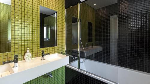 un bagno con due lavandini e piastrelle gialle di Casa dos Pelargónios a Luz
