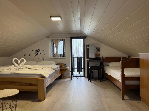 een slaapkamer op zolder met 2 bedden en een tafel bij Kuća za odmor Hrešć in Donji Koncovčak