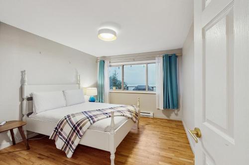 a bedroom with a white bed and a window at Saltwind Shores in Moclips