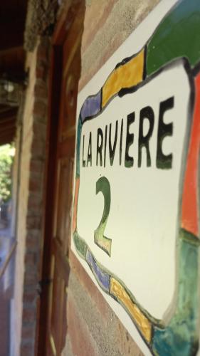 Et logo, certifikat, skilt eller en pris der bliver vist frem på la riviere